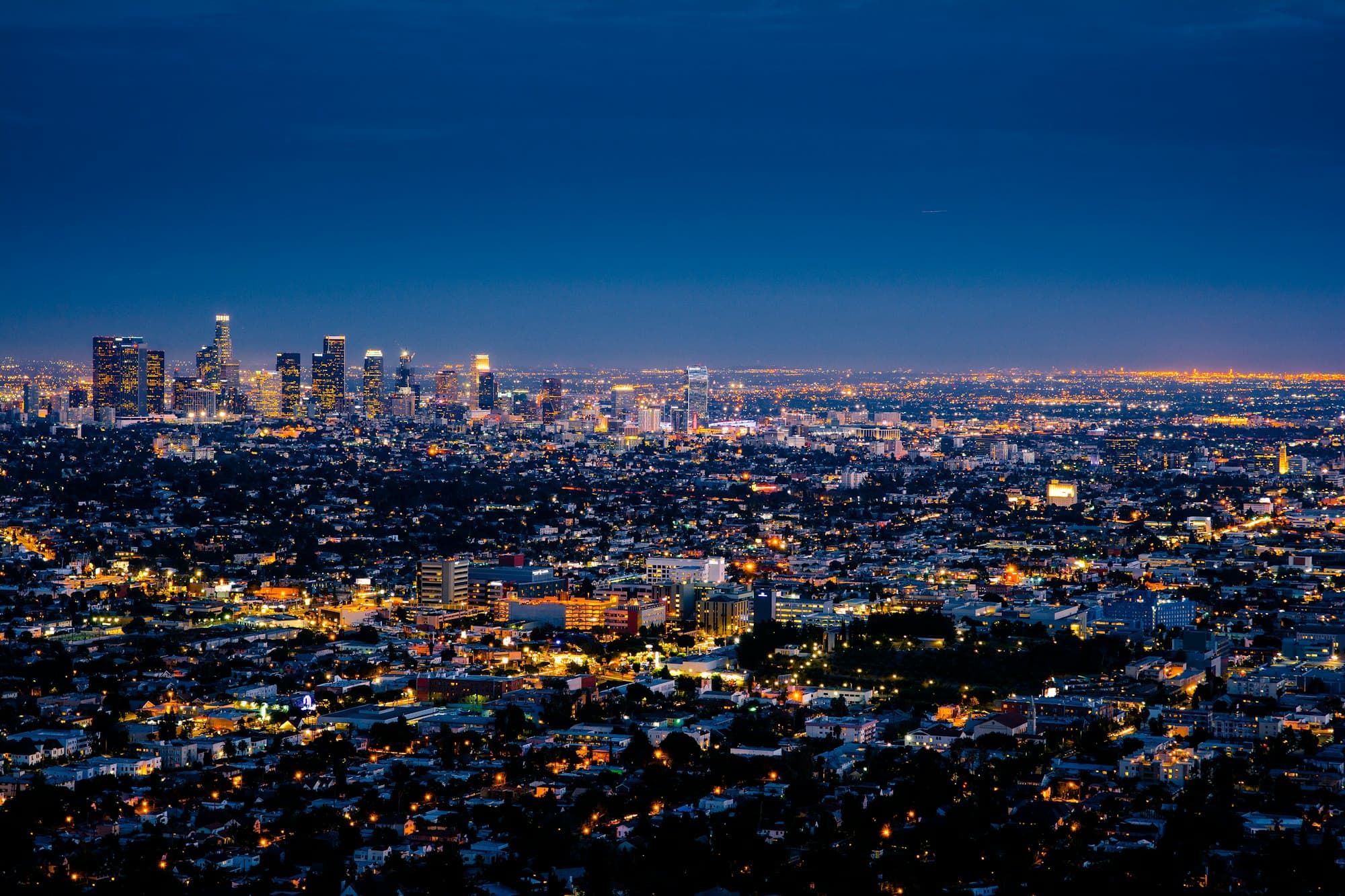 A vast illuminated city at night seen from above